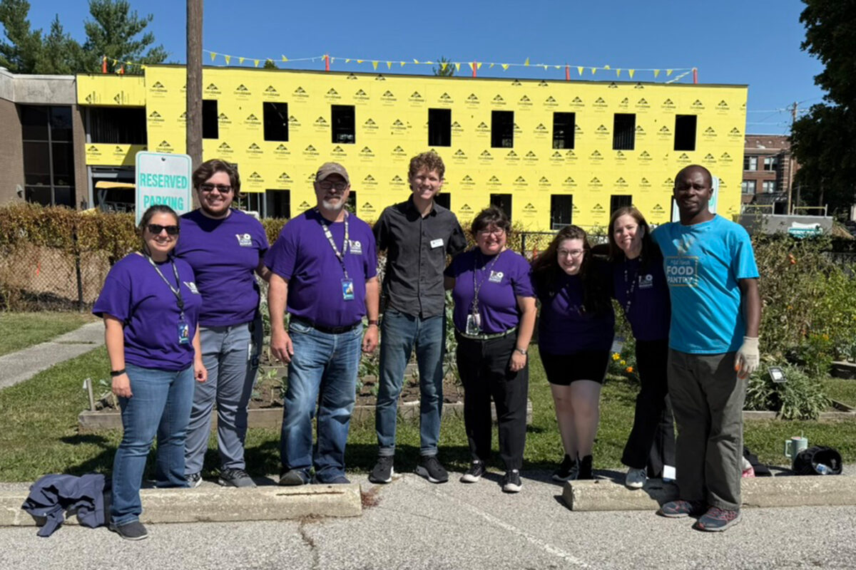 Volunteers in matching shirts, smiling and volunteering as a group