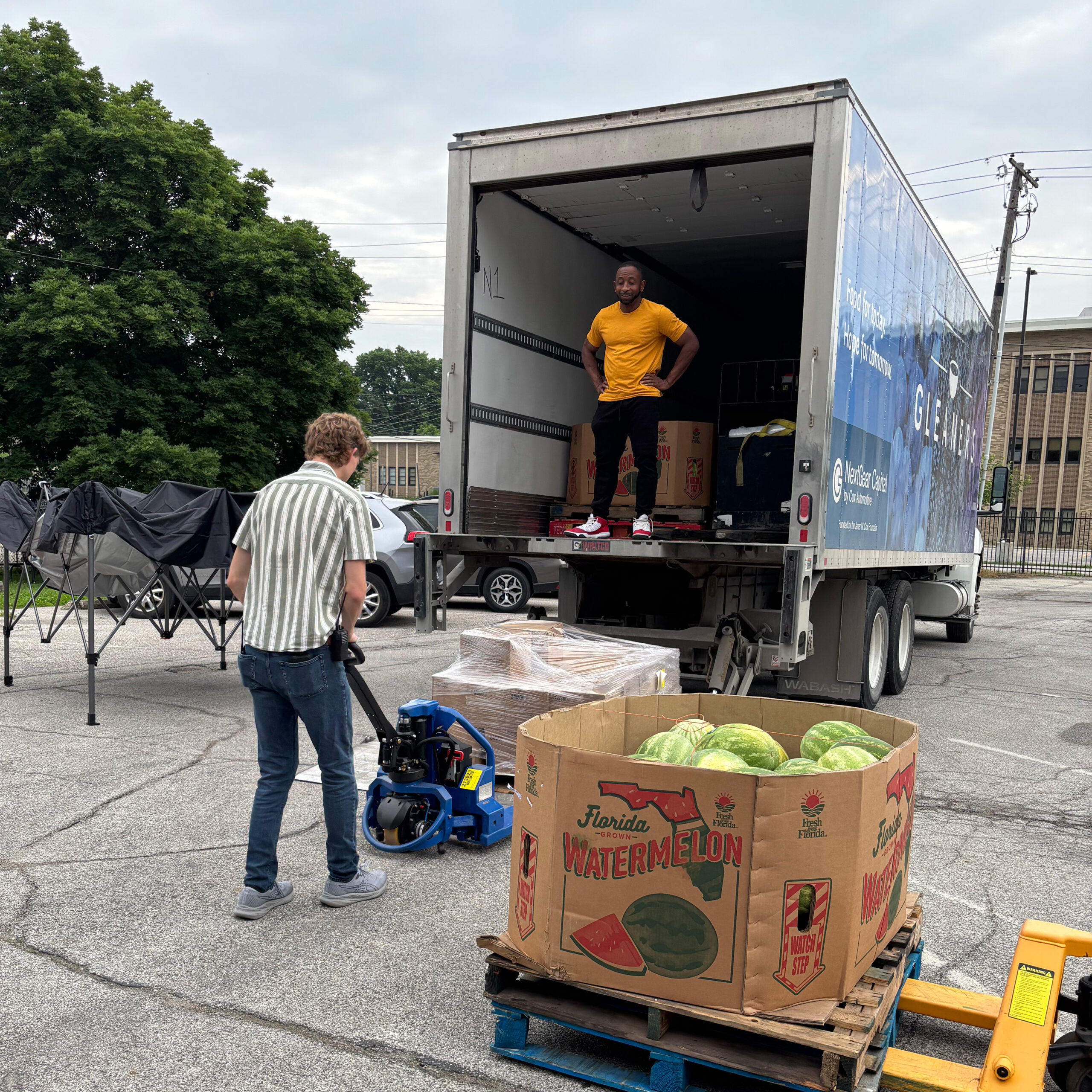 Volunteers helping load and unload food from a truck
