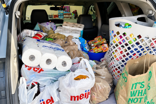 The back of a car loaded with food and supplies